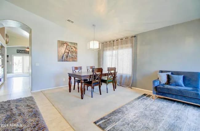 Staged dining area with a wood table and blue sofa in an Arizona home