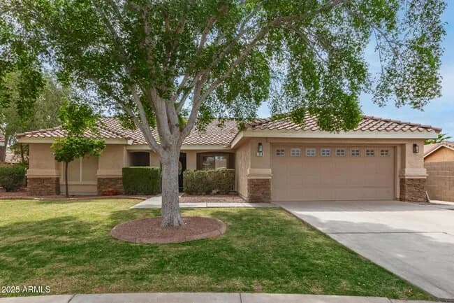 Single-storey Arizona home with a tile roof and a mature shade tree